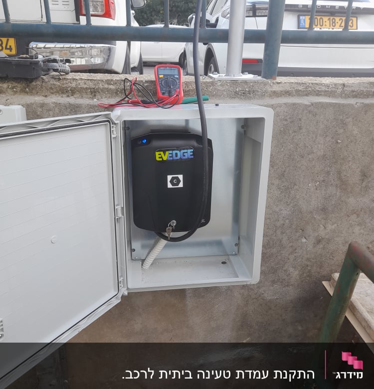 ארון חשמל פתוח עם מטען רכב חשמלי ומולטימטר